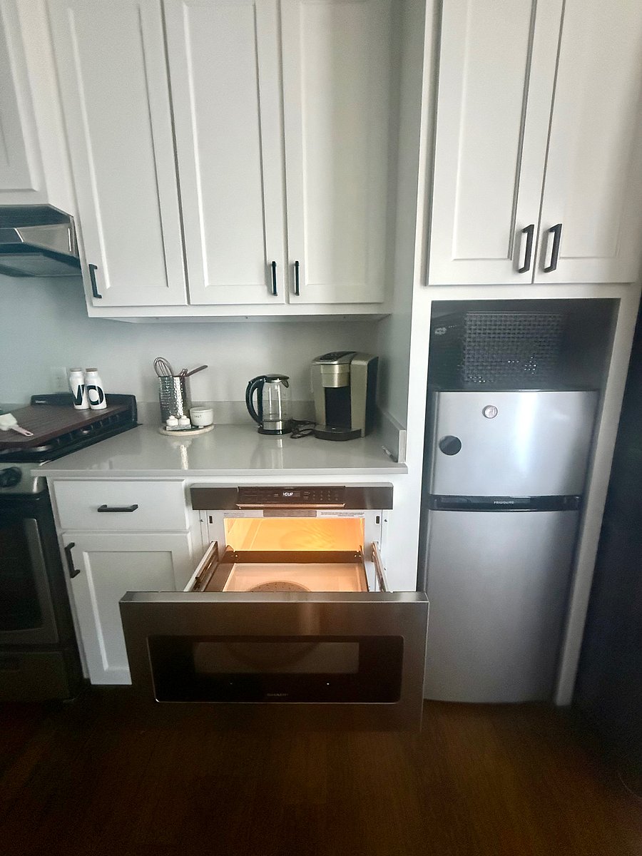Keurig coffee maker, kettle for tea/hot chocolate, and drawer style microwave.