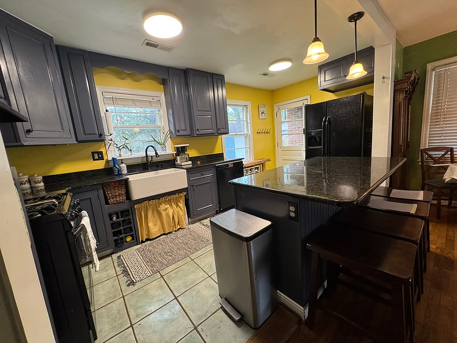 Kitchen features freshly painted cabinets, walls, and trim. Cafe setup to the right for eating meals. Large island perfect for entertaining and comfortable bar stools. Features ample lighting, full-size appliances, and plenty of pots, pans, and dishes.