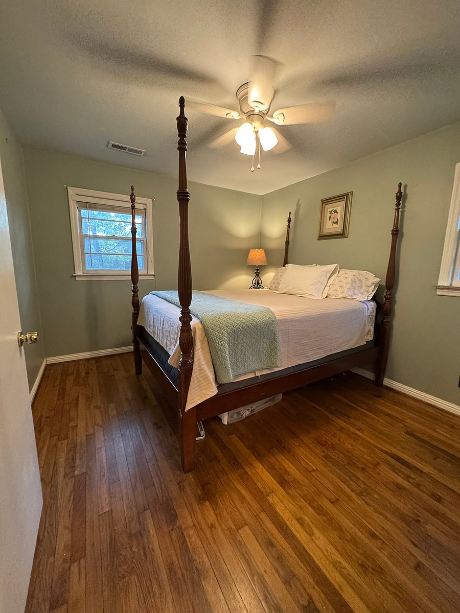 The serene primary bedroom is the perfect place to relax, unwind, and snuggle up. Includes a four-poster bed, lamps, dresser, and closet. Also has its own 1/2 bath (see other photo).