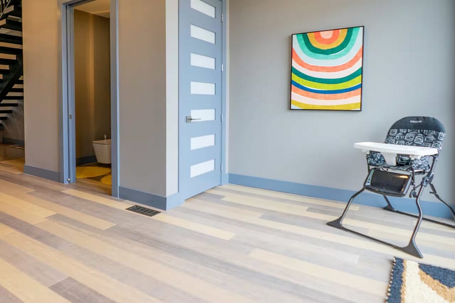 An open layout connects living seating to the kitchen with a linear fireplace.
