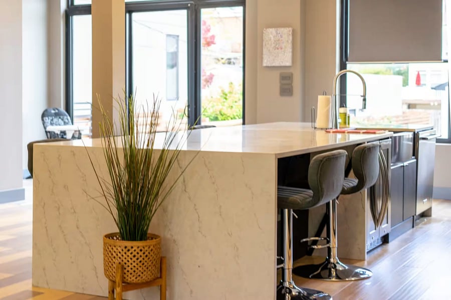 From the kitchen island, look out across bar stools into the bright living room.