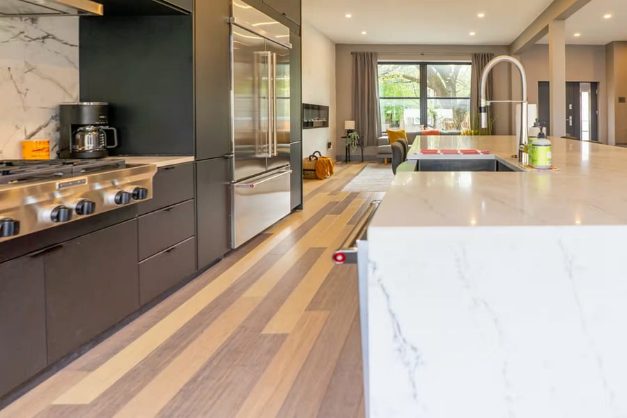 Cook in this modern kitchen with a marble waterfall island and dark cabinetry.