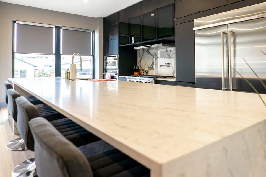 Dark cabinetry and marble surfaces open straight through to the living area.