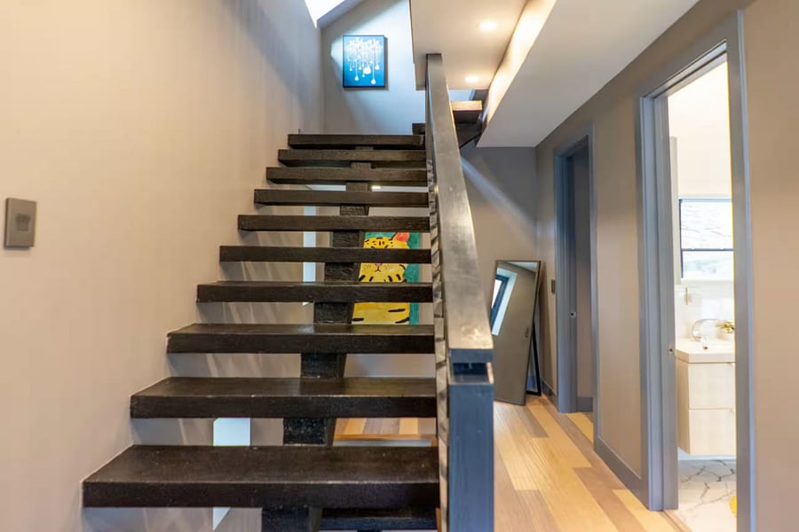 This bright bedroom includes a large bed, bird wall art, and a portable crib.