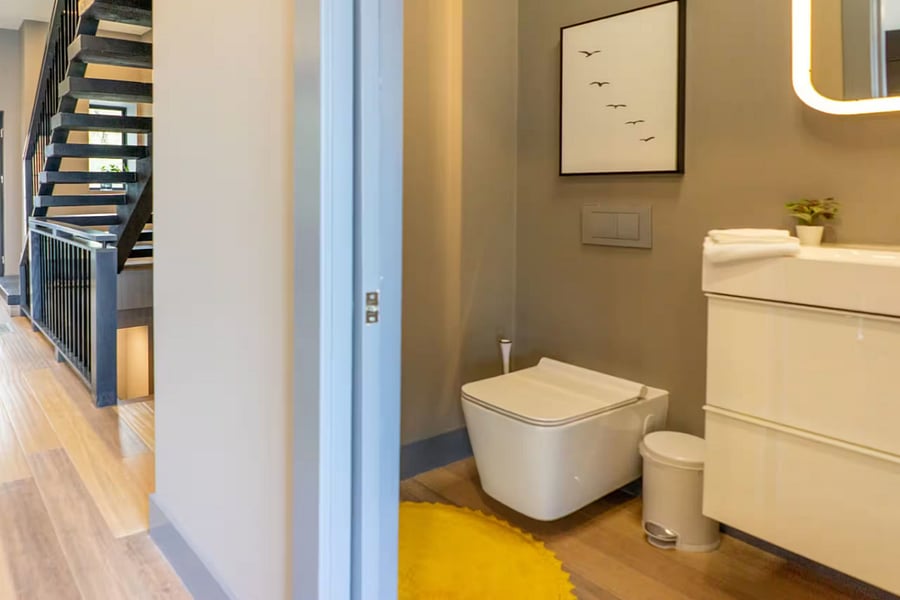 The ensuite pairs a wood floating vanity with a glass-enclosed walk-in shower.