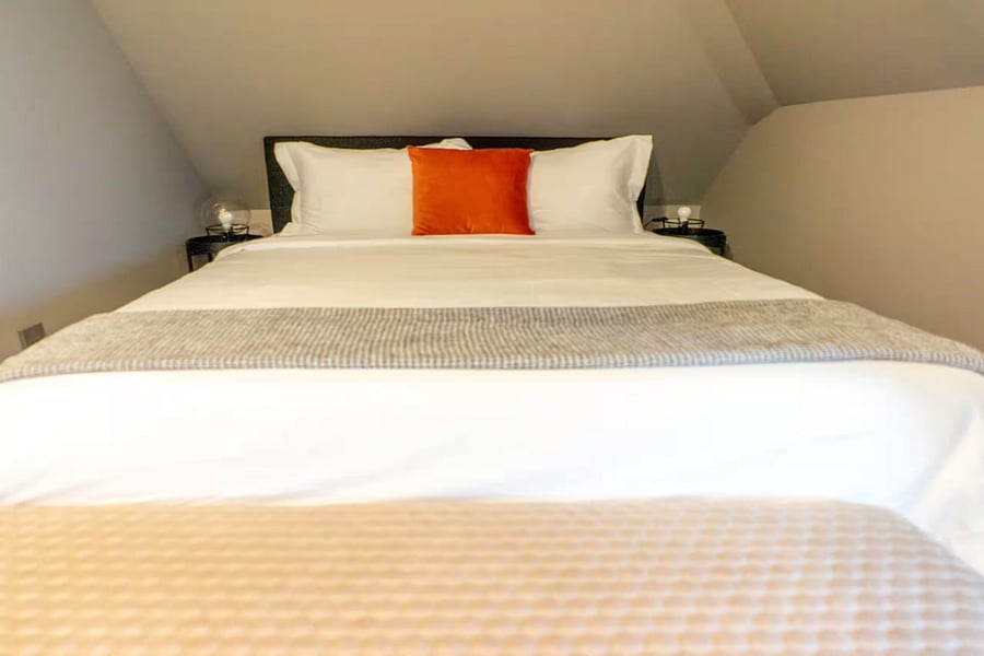 An upper landing hall brings natural light past modern stairs and bedroom doors.