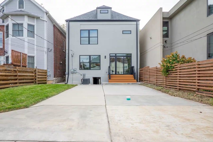 The rear of the home opens to a wide concrete driveway and fenced yard.