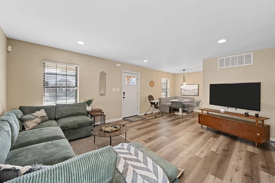 Rest in this spacious bedroom featuring a plush grey bed and wall-mounted TV.