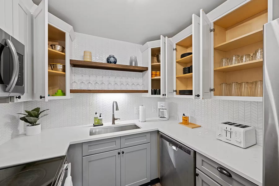 The updated bathroom features a double vanity with modern black fixtures.