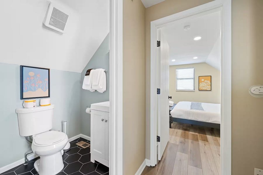 Another view of the bedroom shows a wall-mounted TV and natural light.