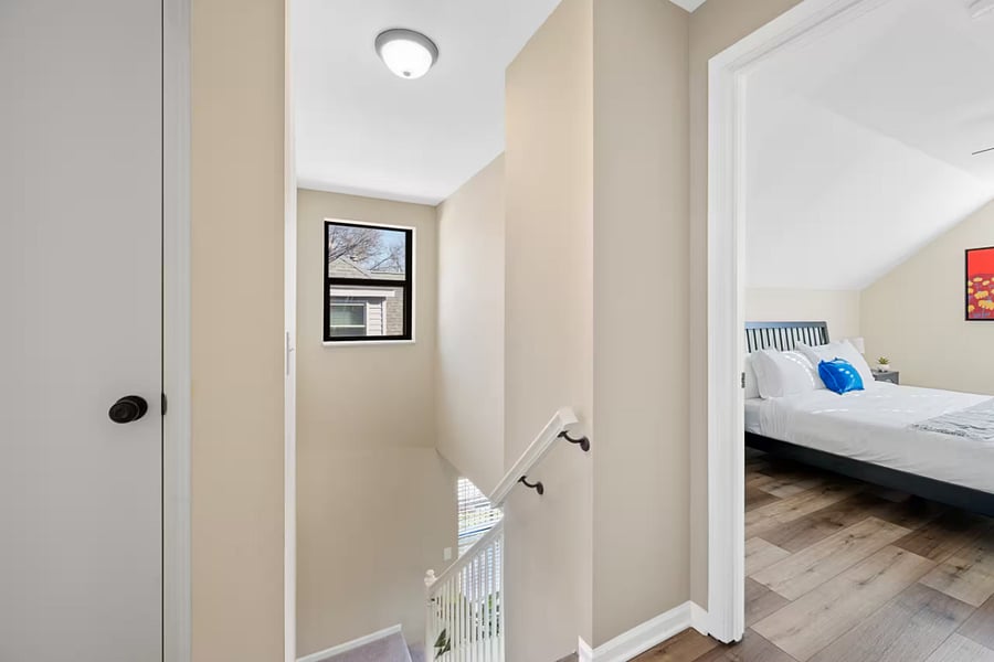 This upstairs bedroom offers a large bed, ceiling fan, and wall-mounted TV.