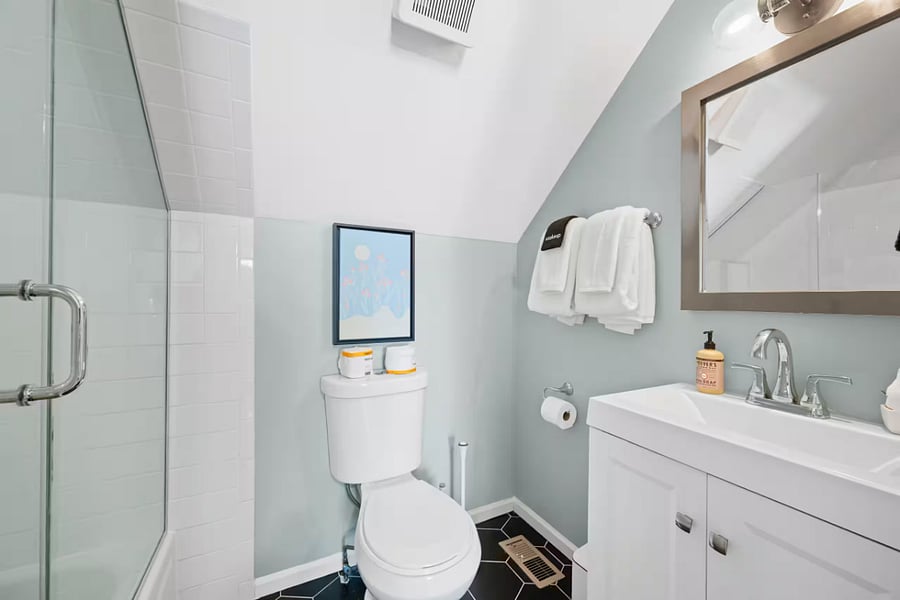 Soft linens and a ceiling fan make this sloped-ceiling bedroom a cozy retreat.
