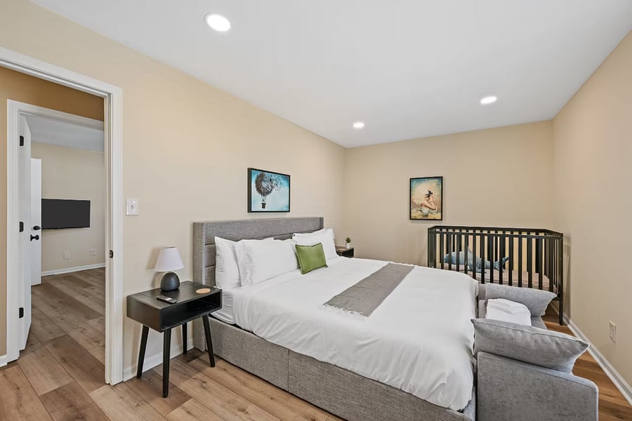 This attic-style bedroom includes a comfortable bed, TV, and portable crib.