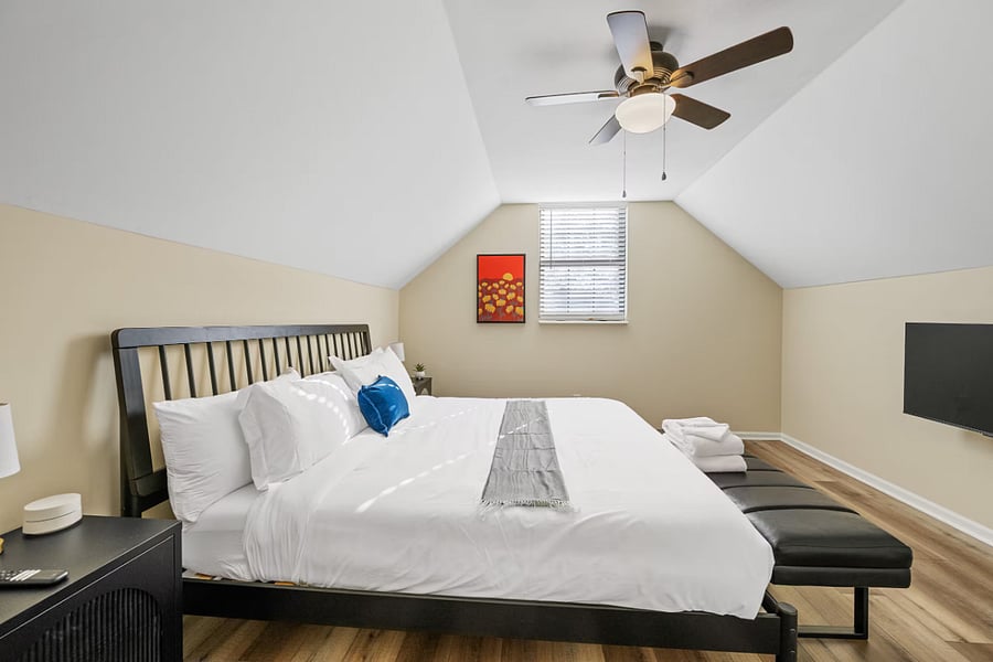 Upstairs, a stylish bath sits just steps from a cozy bedroom.