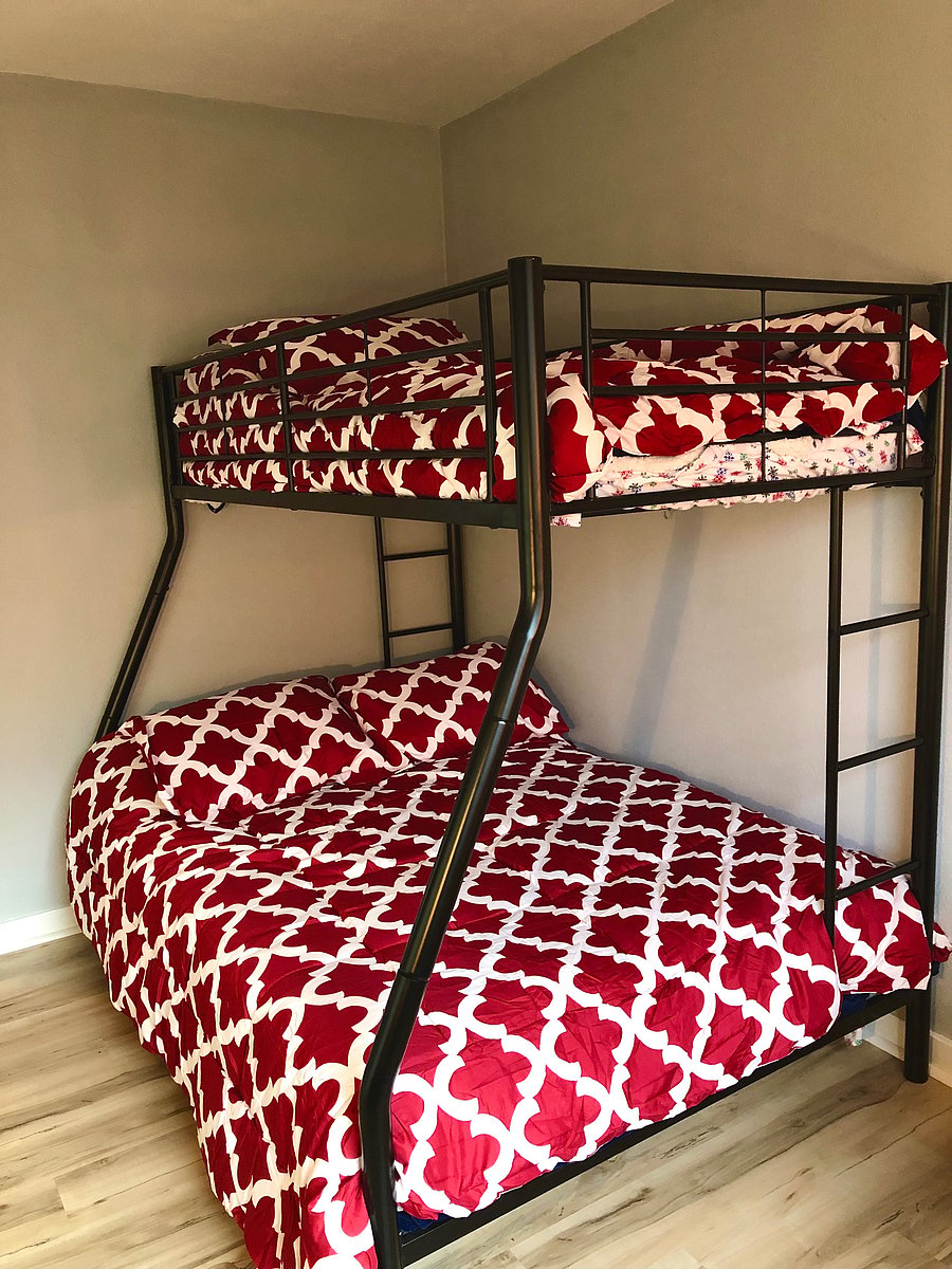 3rd bedroom has twin over queen bunk beds, computer desk, sitting area and closet.