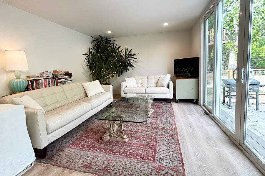 Family room with a leather sofa and love seat, opens up to the back patio