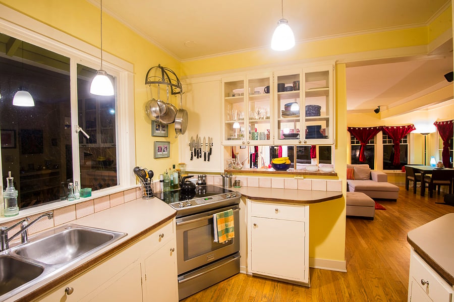 Fully-stocked kitchen opens to living and dining room. Modern appliances include an induction stove, oven, dishwasher, refrigerator and microwave.