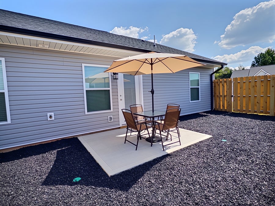 Fenced backyard w/patio furniture.