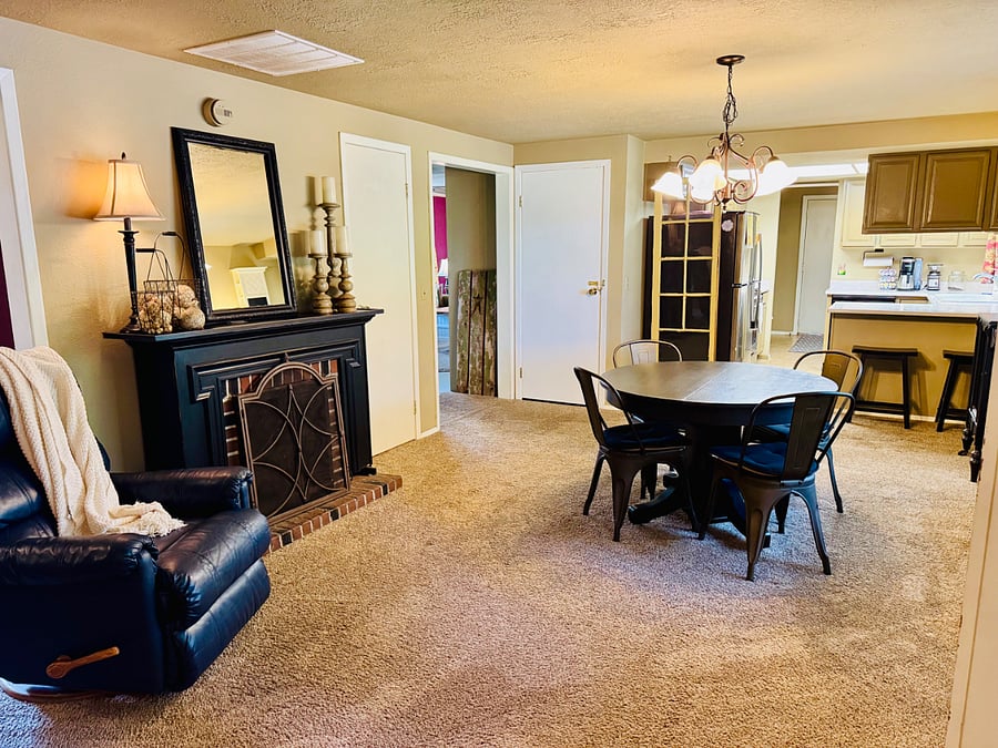 Dining room with view of kitchen and fireplace.