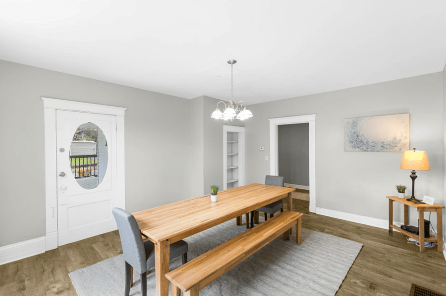 The dedicated dining room features a charming farmhouse-style table with bench seating, creating a warm and inviting space for shared meals and conversation.