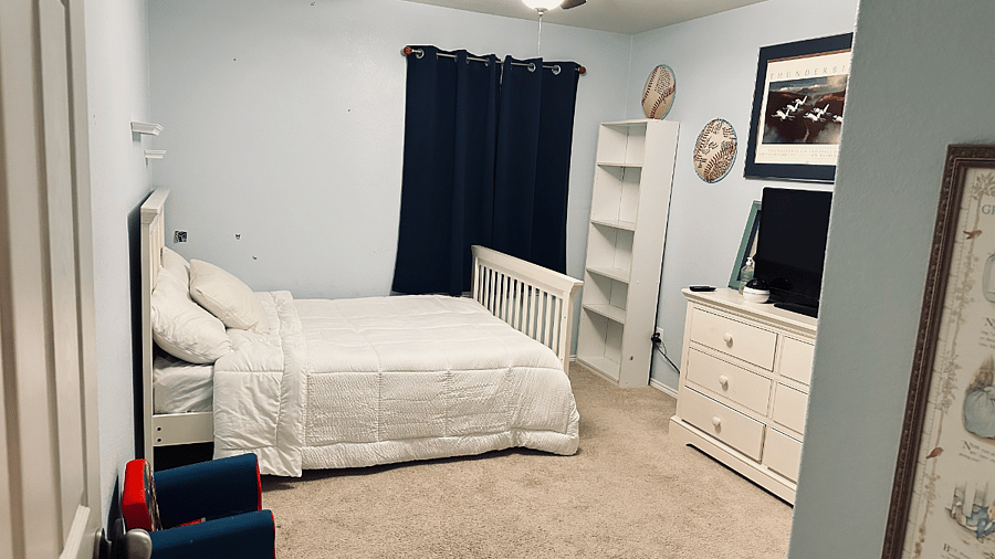 Upstairs bedroom with TV, dresser, and bookshelf