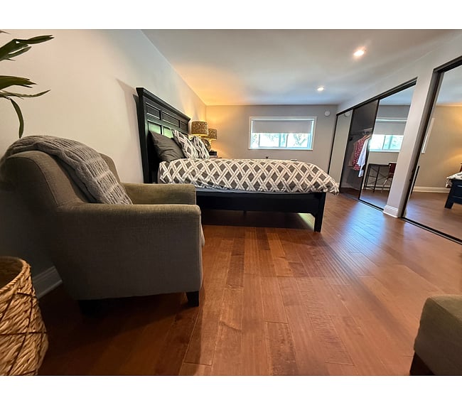 Furnishings: Queen-size bed, mid-century walnut dresser, lamps, fan, club chair & matching ottoman.