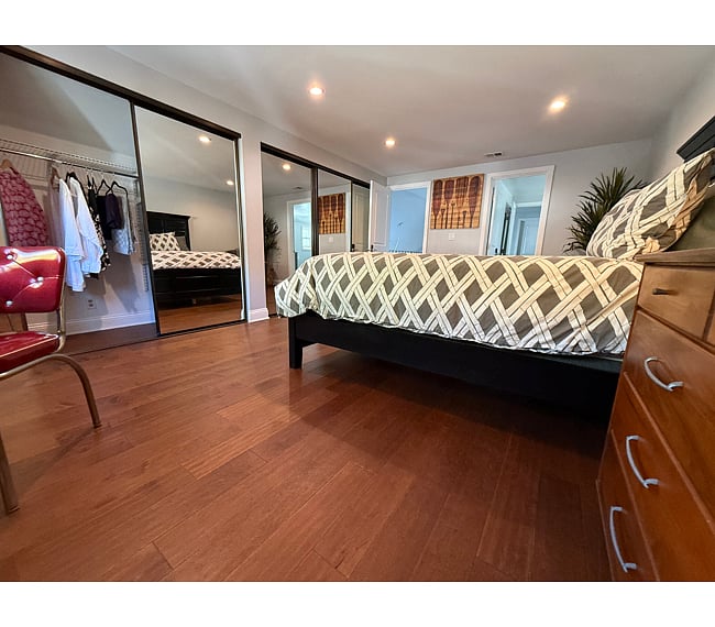 Furnishings: Queen-size bed, mid-century walnut dresser, lamps, fan, club chair & matching ottoman. Bedding included.