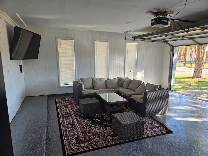 Garage area with large screen TV and dart board.