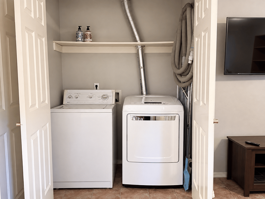 Laundry with full sized washer and dryer, central vacuum, and other cleaning supplies