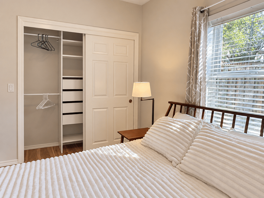 Bedroom closet with closet organizer, drawers, and hangers