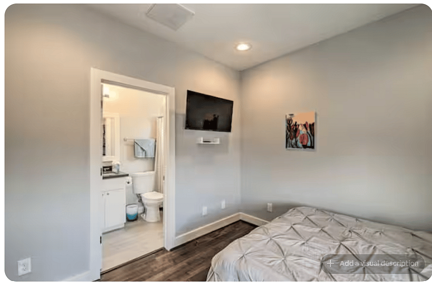 Comfortable bedroom with warm wood floors, colorful artwork & wall-mounted TV.
Direct access to a private bathroom adds convenience and privacy.
Recessed lighting and a clean, modern design create a relaxing retreat.