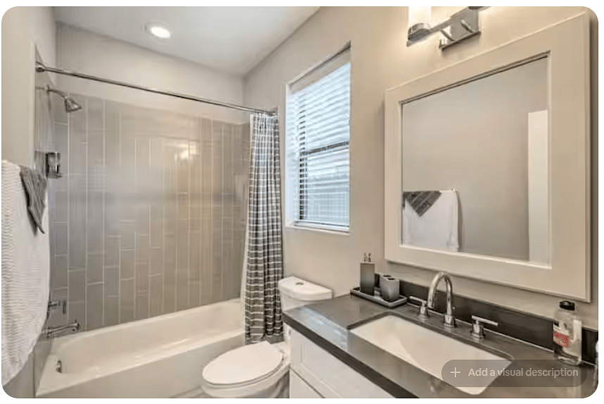 Bright full bathroom with a tub/shower combination, modern tile surround & large vanity.
Oversized mirror and contemporary lighting keep the space bright, while a window adds natural light.
Clean finishes make it fresh and functional.