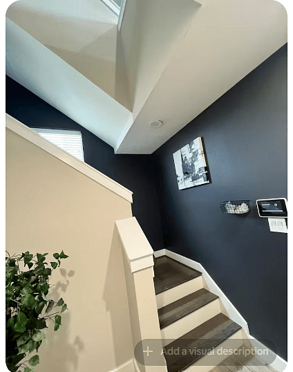 Modern interior staircase connecting the homes multiple levels, with warm wood-look steps and crisp white trim.
A dramatic dark accent wall, artwork & natural light add character while showing the homes multi-level layout.