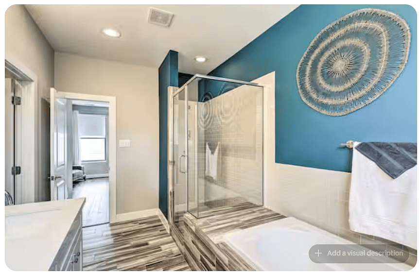 Spacious bathroom featuring a glass-enclosed walk-in shower and separate soaking tub.
Bold blue accent walls add character, while modern tile flooring, recessed lighting & decorative wall art create a polished retreat.