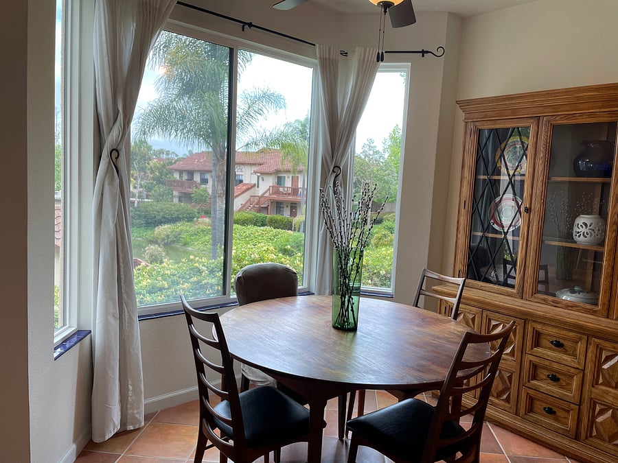 The pictured dining set has been replaced with a glass table and cloth high back chairs.
