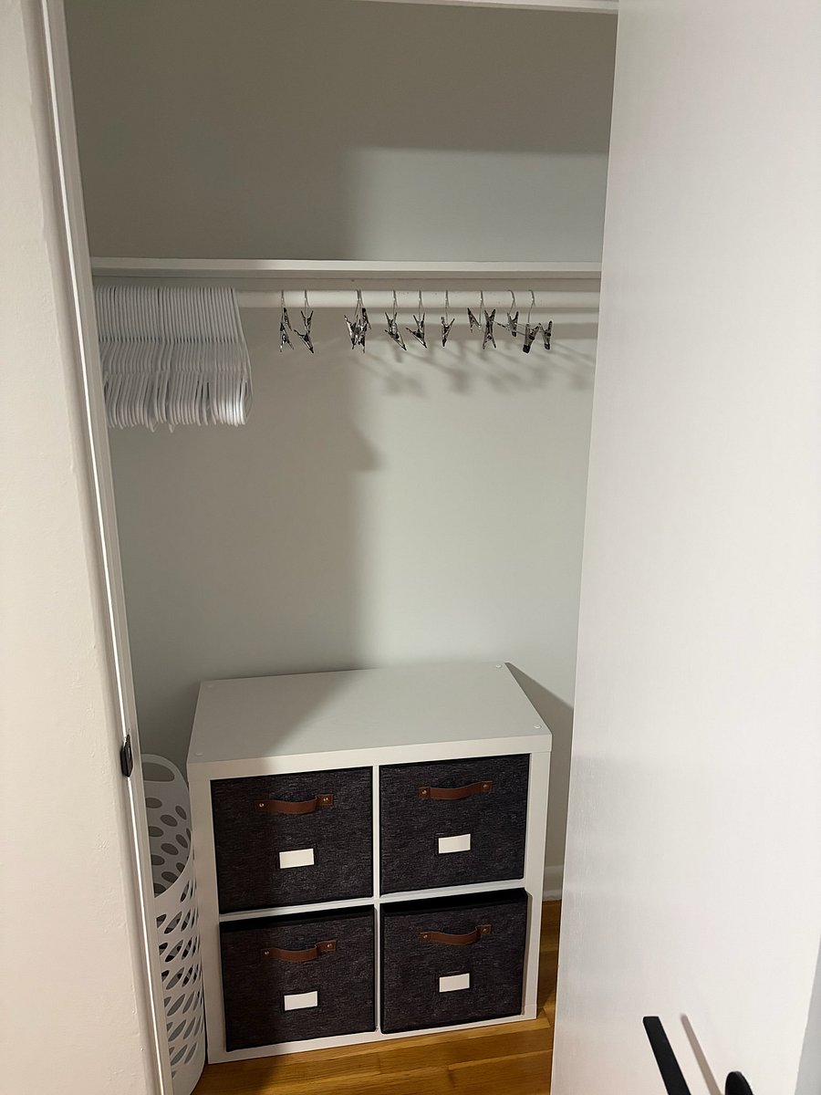 Closet with plenty of hangers, storage cubes, and laundry hamper.