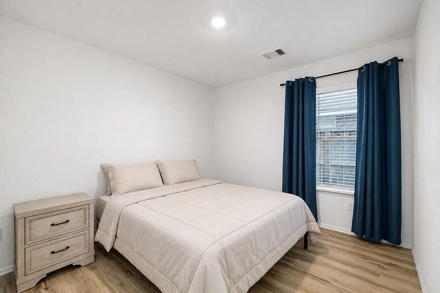 Secondary bedroom with no carpet and large window providing ample lighting. (sheets & covers may vary)