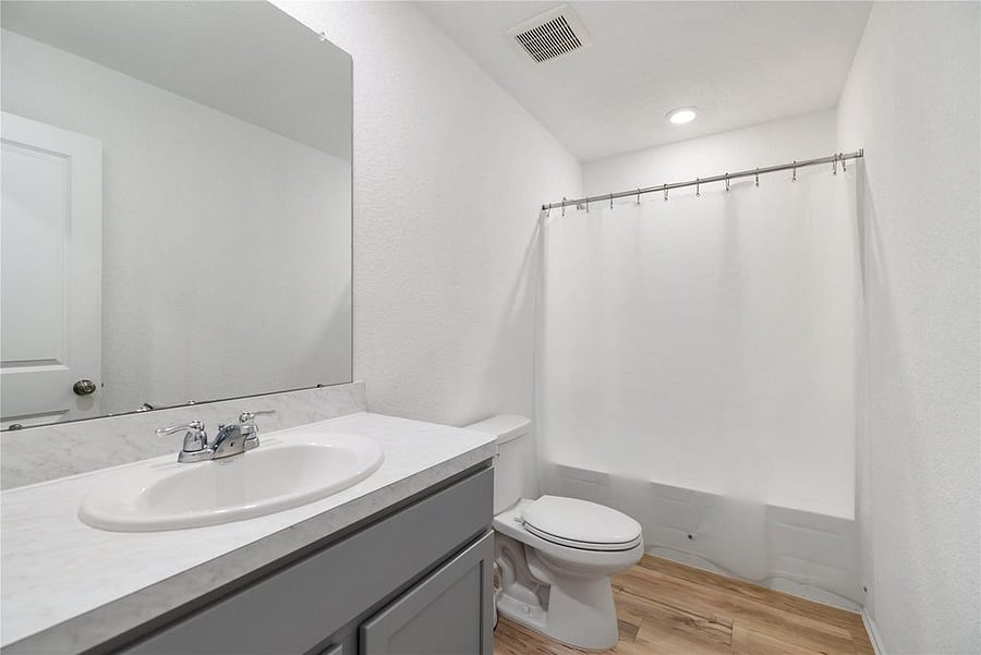 Secondary full bathroom with shower soaking tub combo. Shared with second and third bedroom.