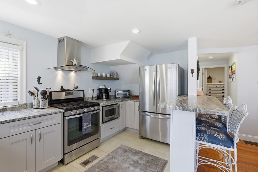 Kitchen with farmhouse style sink, gas stove, coffee maker, microwave, etc