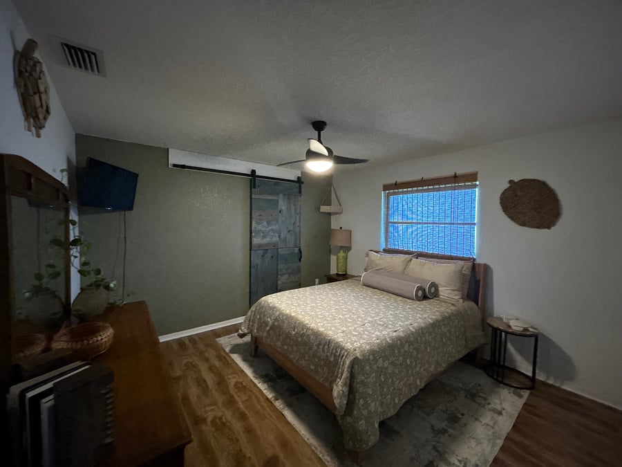 master bedroom with entry (behind sliding barn door) to master bath