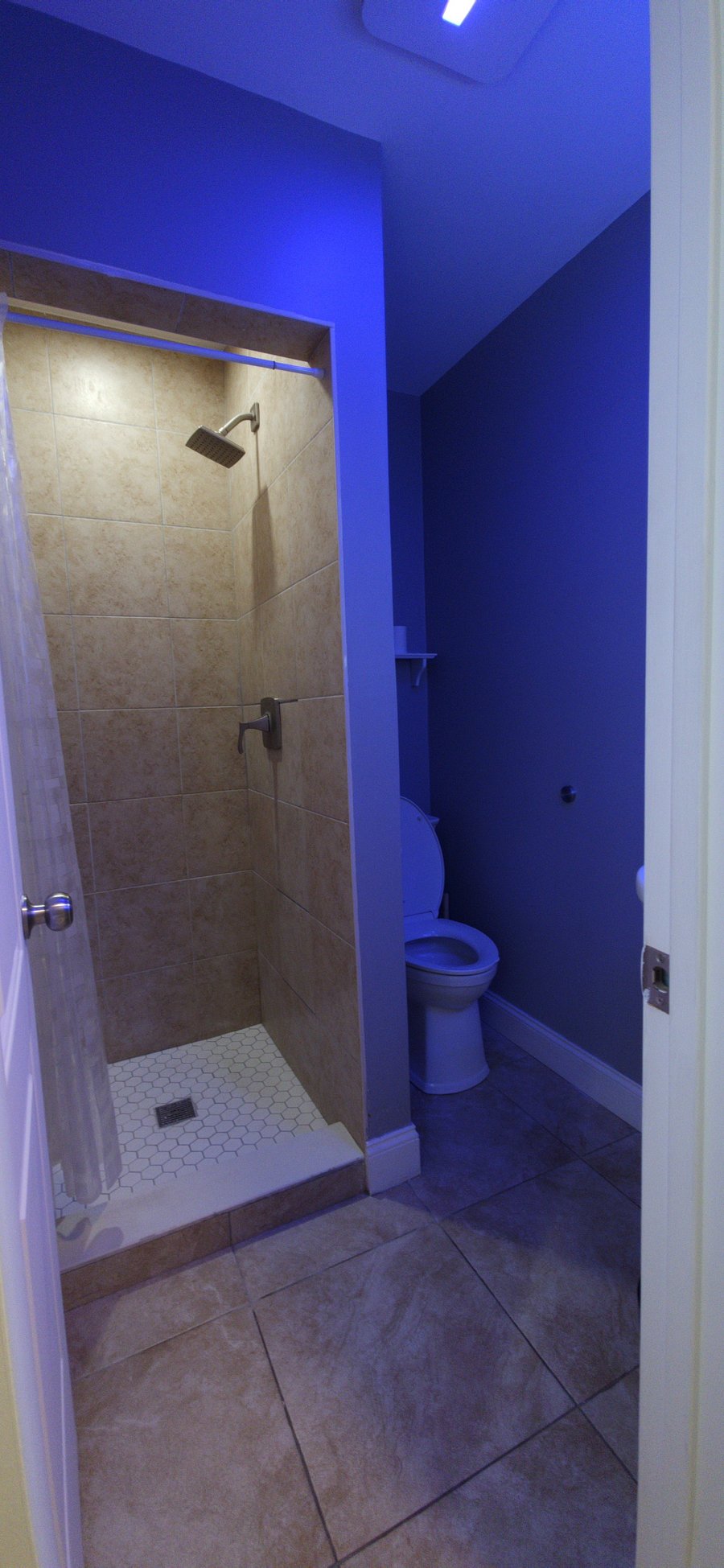 Private bathroom with tiled walk-in shower and rainfall fixture.