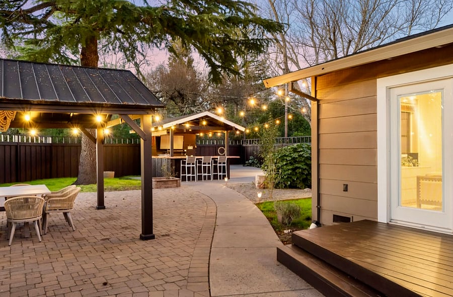 Outdoor kitchen and bar with new drink refrigerator, dining for 8 al fresco, bistro lighting, BBQ, sink, flat screen tv (the perfect place to watch a game)