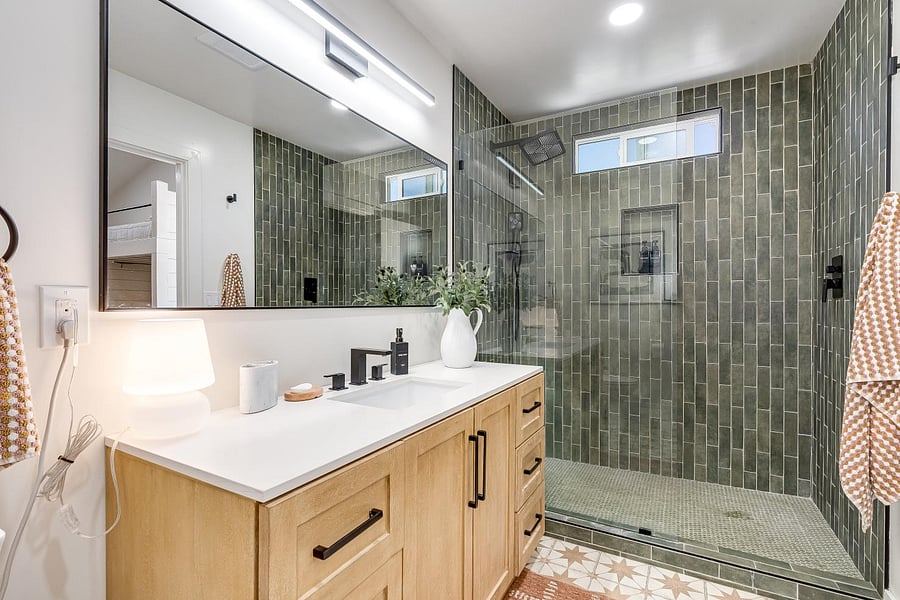 Newly renovated bathroom with tub and rain shower. Storage in mirror and in vanity. 