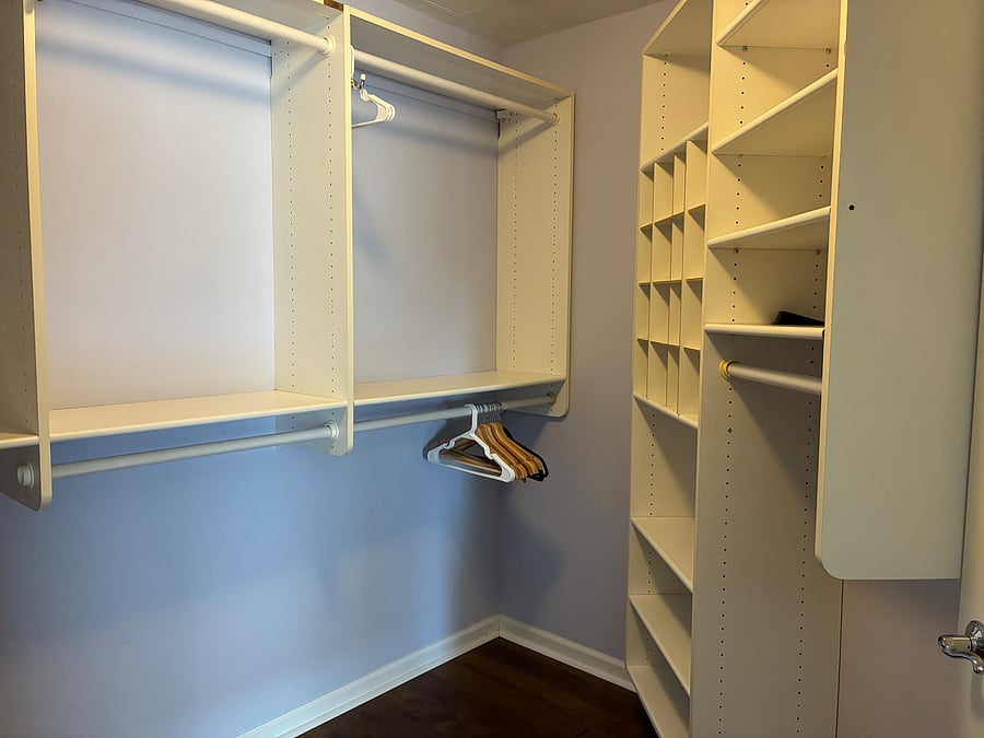Walk-in closet with built ins and clothes hamper.