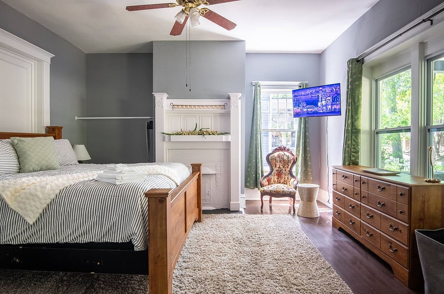 Continuing through the home, you'll step into a cheerful guest room featuring a comfortable queen bed, TV for entertainment, and a dresser to keep your stay organized and relaxed.