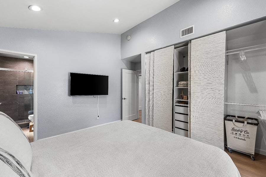 Primary bedroom with TV and custom closets