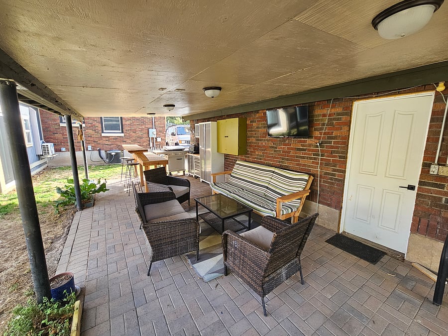 Outdoor hosting space, complete with grill, bar, tv, and plenty of seating.