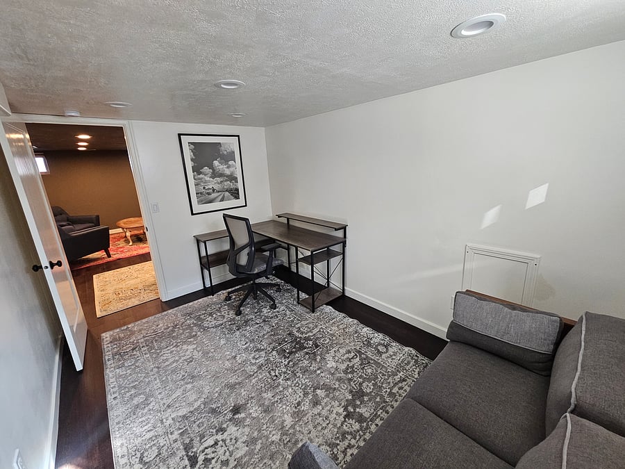 The office, a large desk, ergonomic chair, and a couch to keep you focused on your work or studies.