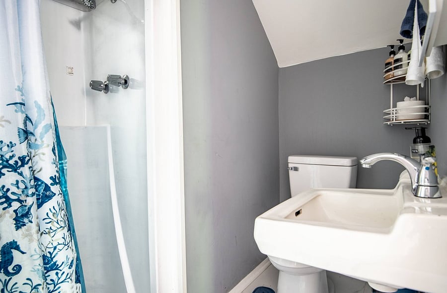 Compact and clean, the bathroom is designed with simplicity in mind. A step-down entry leads into the stand-up shower, and while the space is smaller, it's efficient, well-kept, and equipped with everything you need for a comfortable stay.