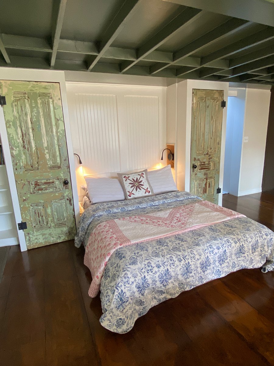 A queen sized Select Comfort/Sleep Number bed with closet space to the left and shelves behind doors on the right.